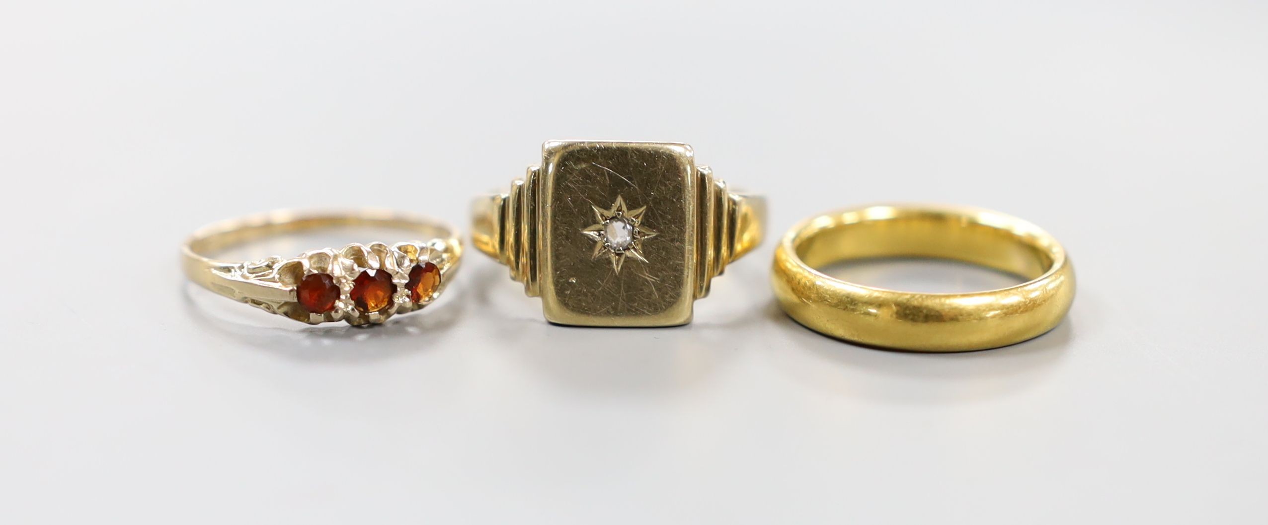 An early 1930's 22ct gold wedding band, size N/O, 7.1 grams and two 9ct gold rings including a mid 20th century diamond set signet ring, gross 8 grams.